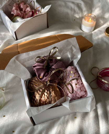 Decorative items including a candle, flowers, and a box on a light surface.